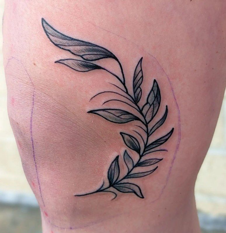 Fresh fine line tattoo of a leafy branch