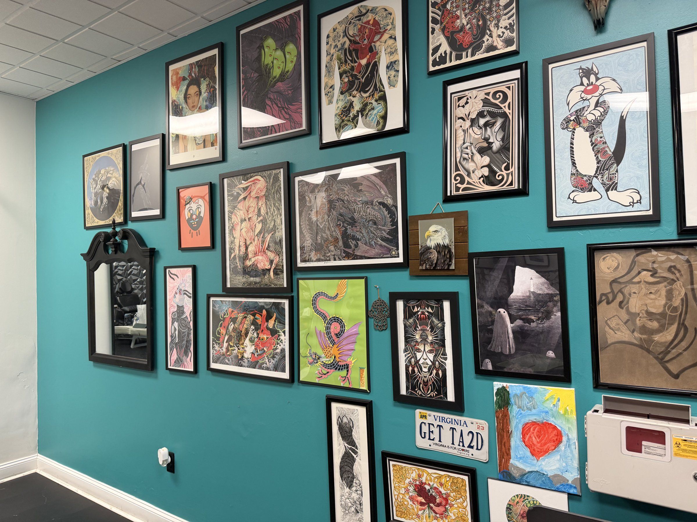 The turquoise wall at Turquoise Panther Tattoo, covered floor to ceiling in framed flash and art